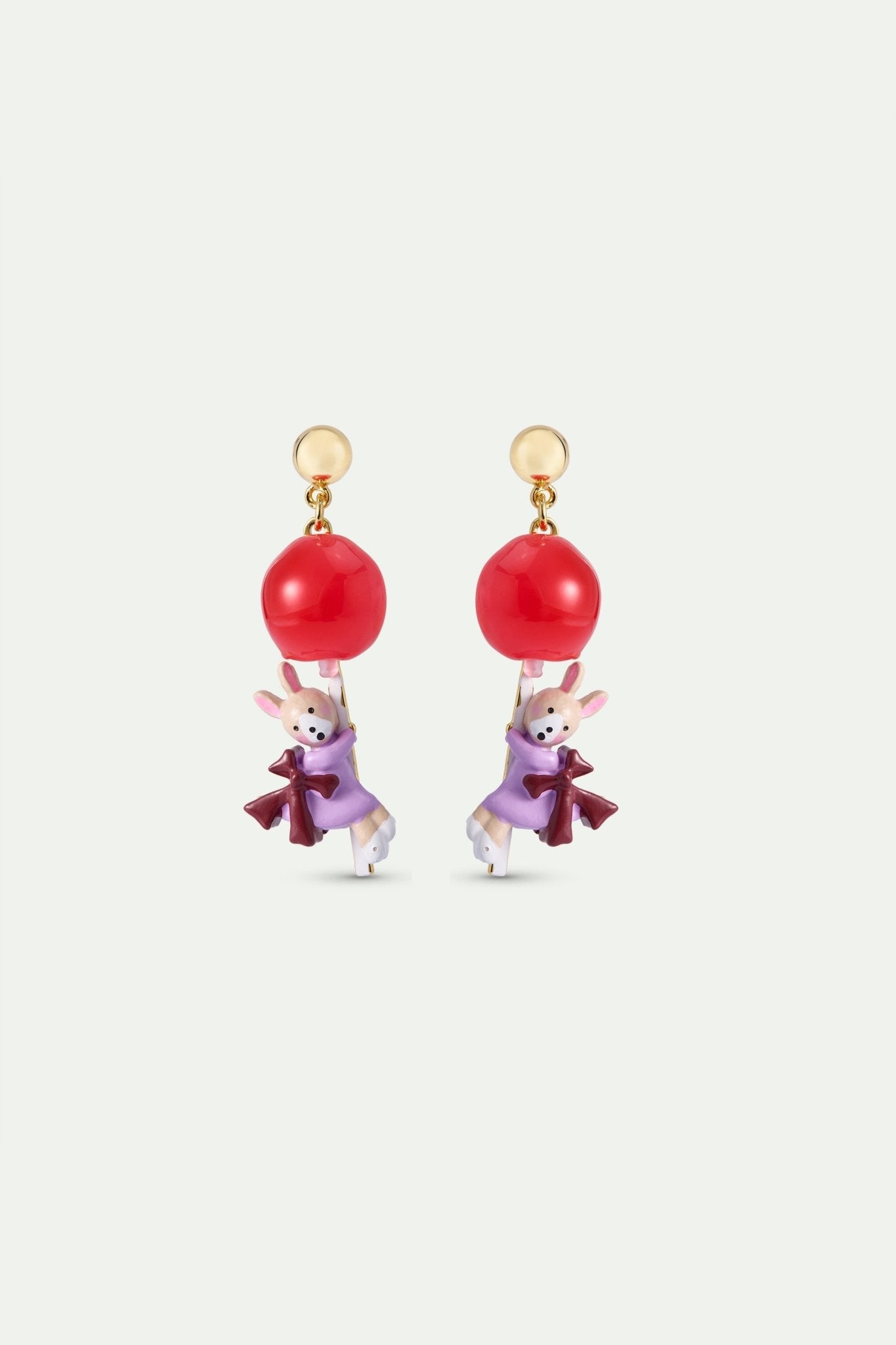 Earrings with red ball and rabbit design on a light gray background
